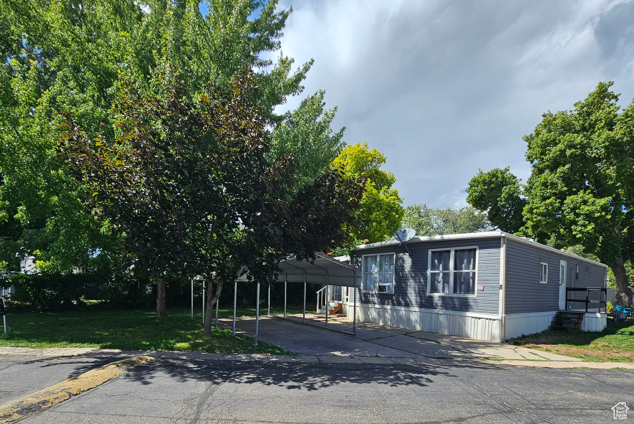 View of front of house with a front lawn and a carport