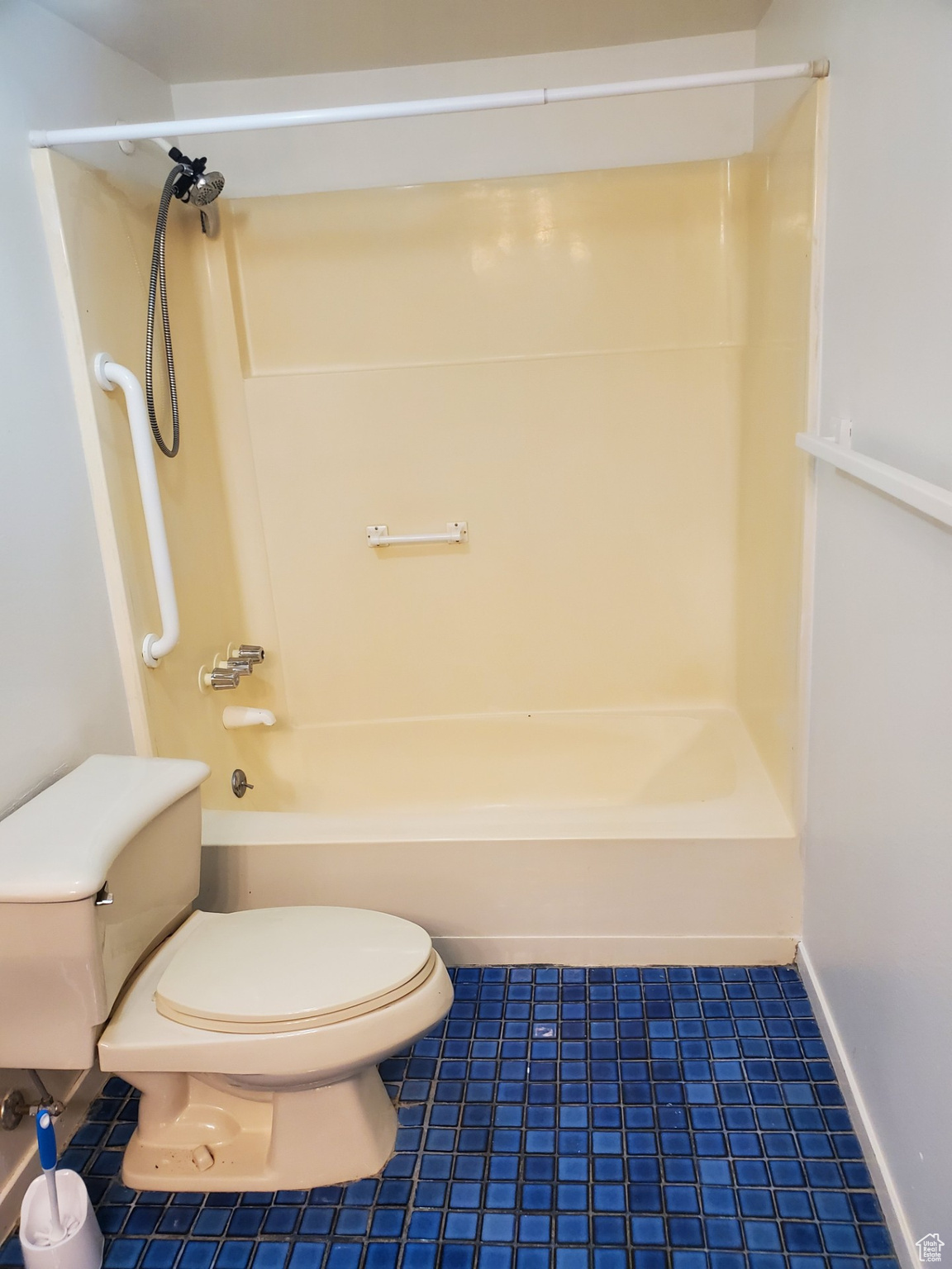 Bathroom with tile floors, shower / bathing tub combination, and toilet