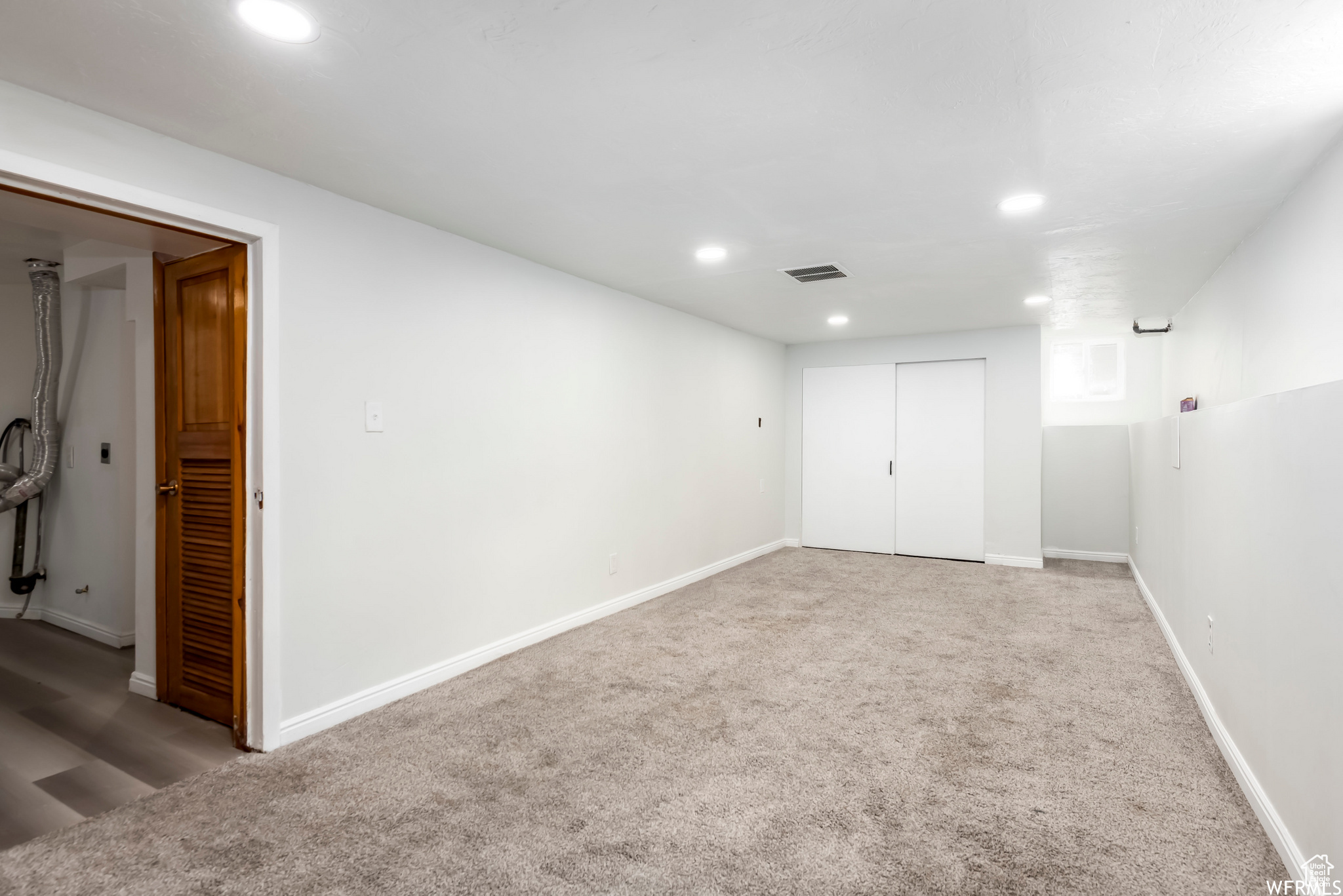 Unfurnished room featuring light carpet