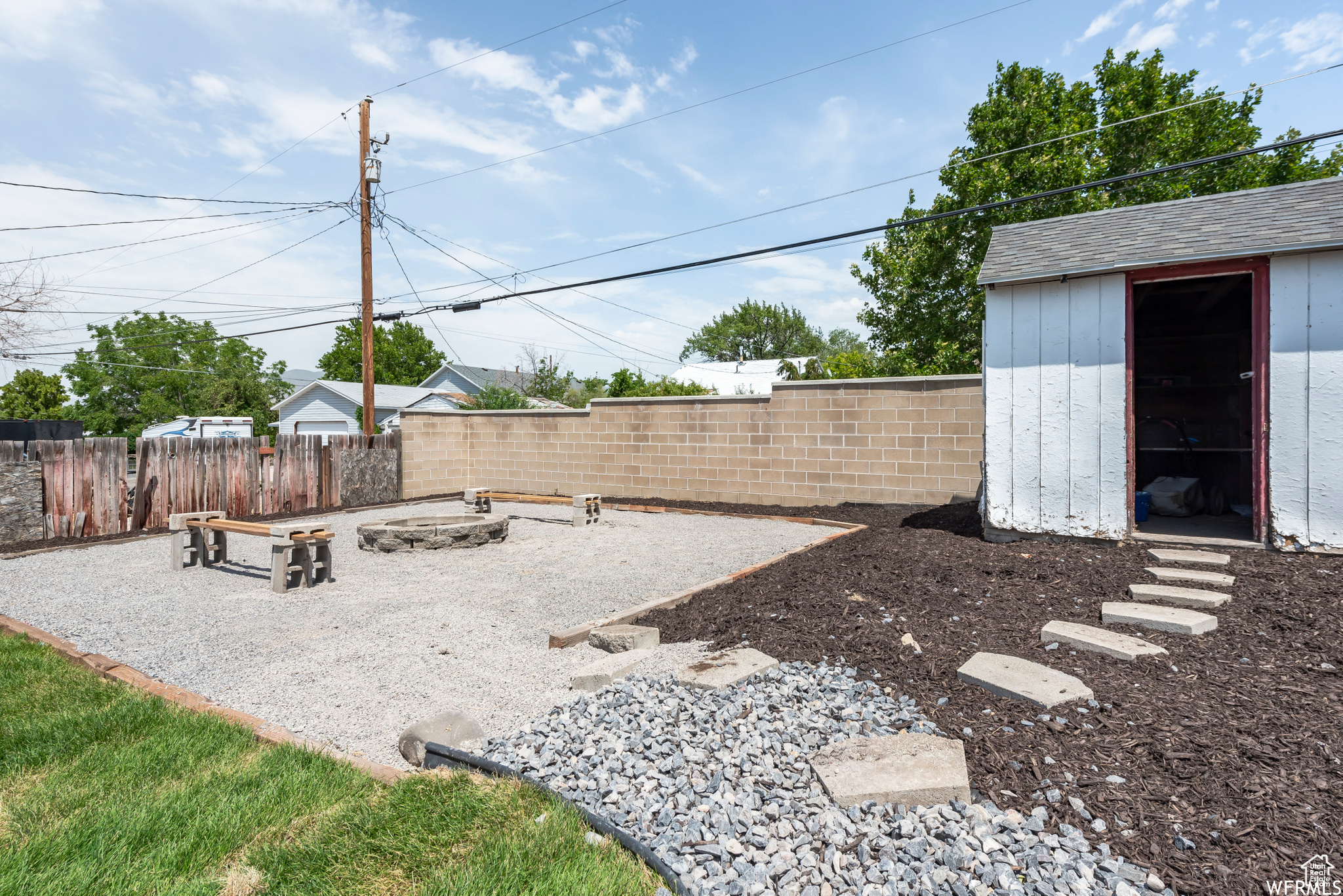 View of yard featuring an outdoor fire pit and a shed