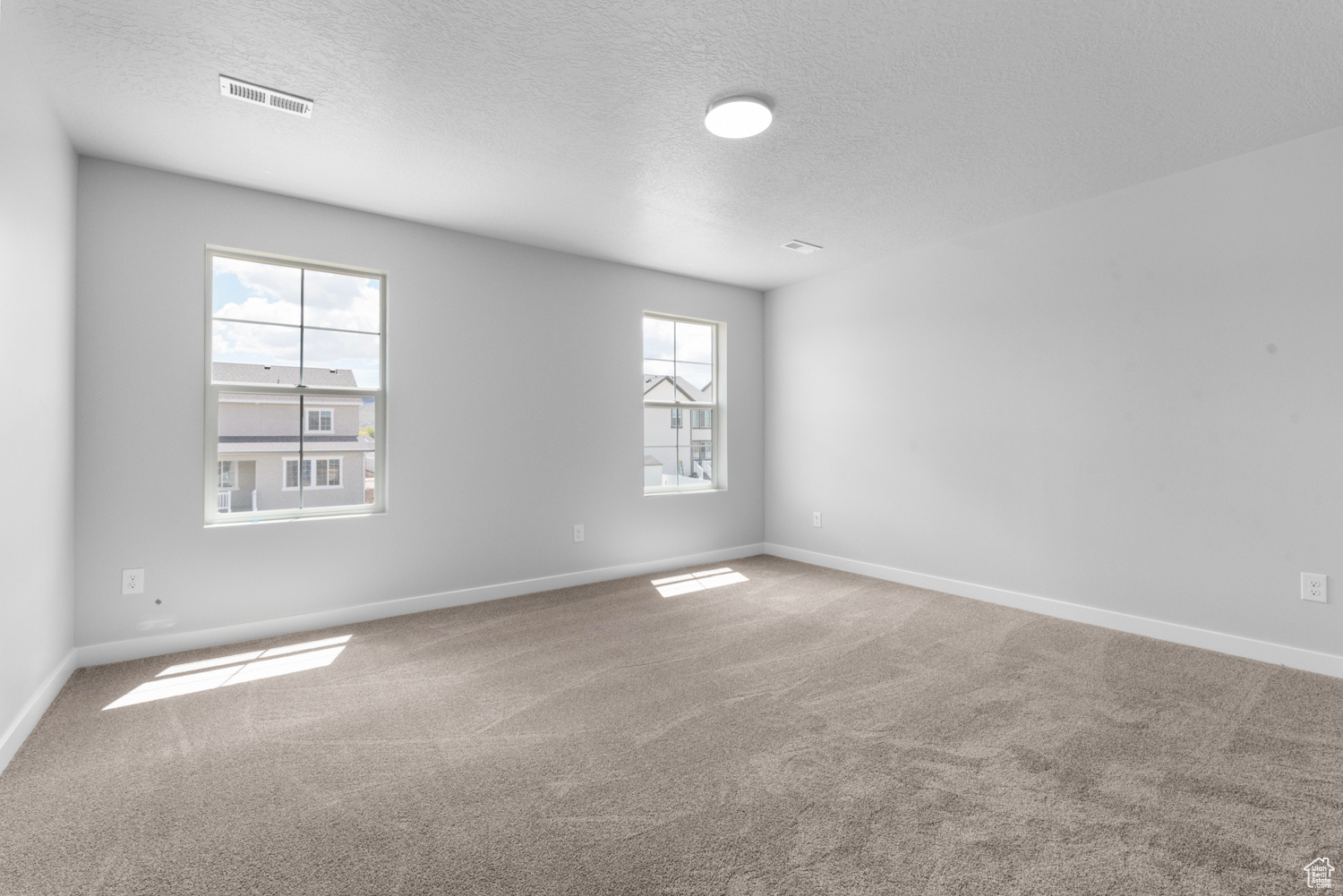 Empty room with carpet and a textured ceiling