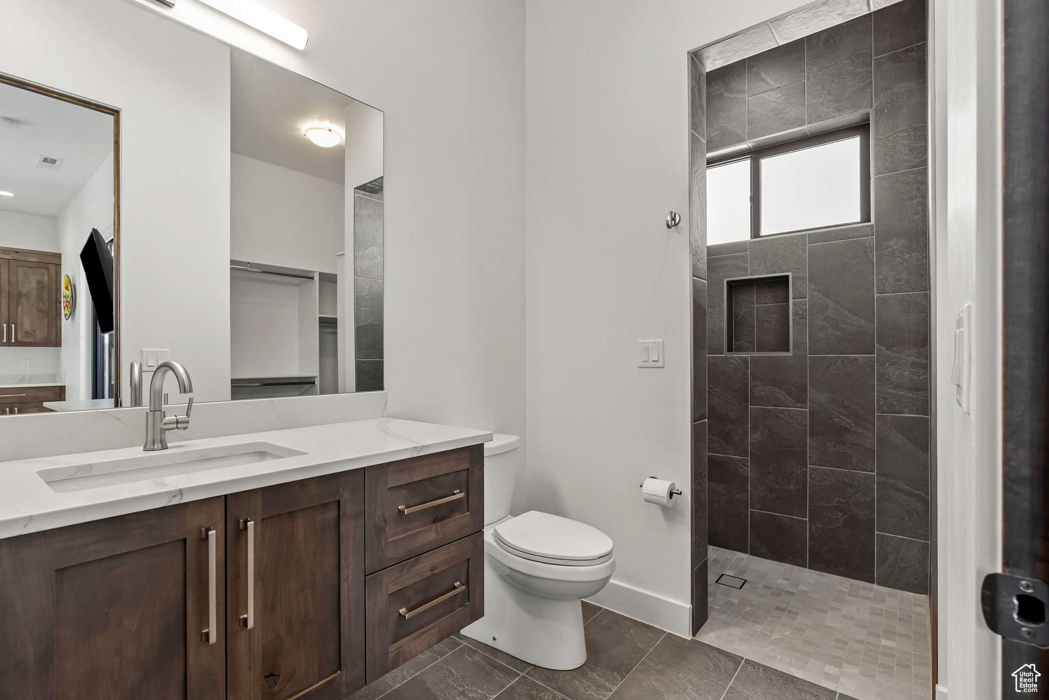 Bathroom featuring tile flooring, tiled shower, vanity, and toilet, Casita Bathroom