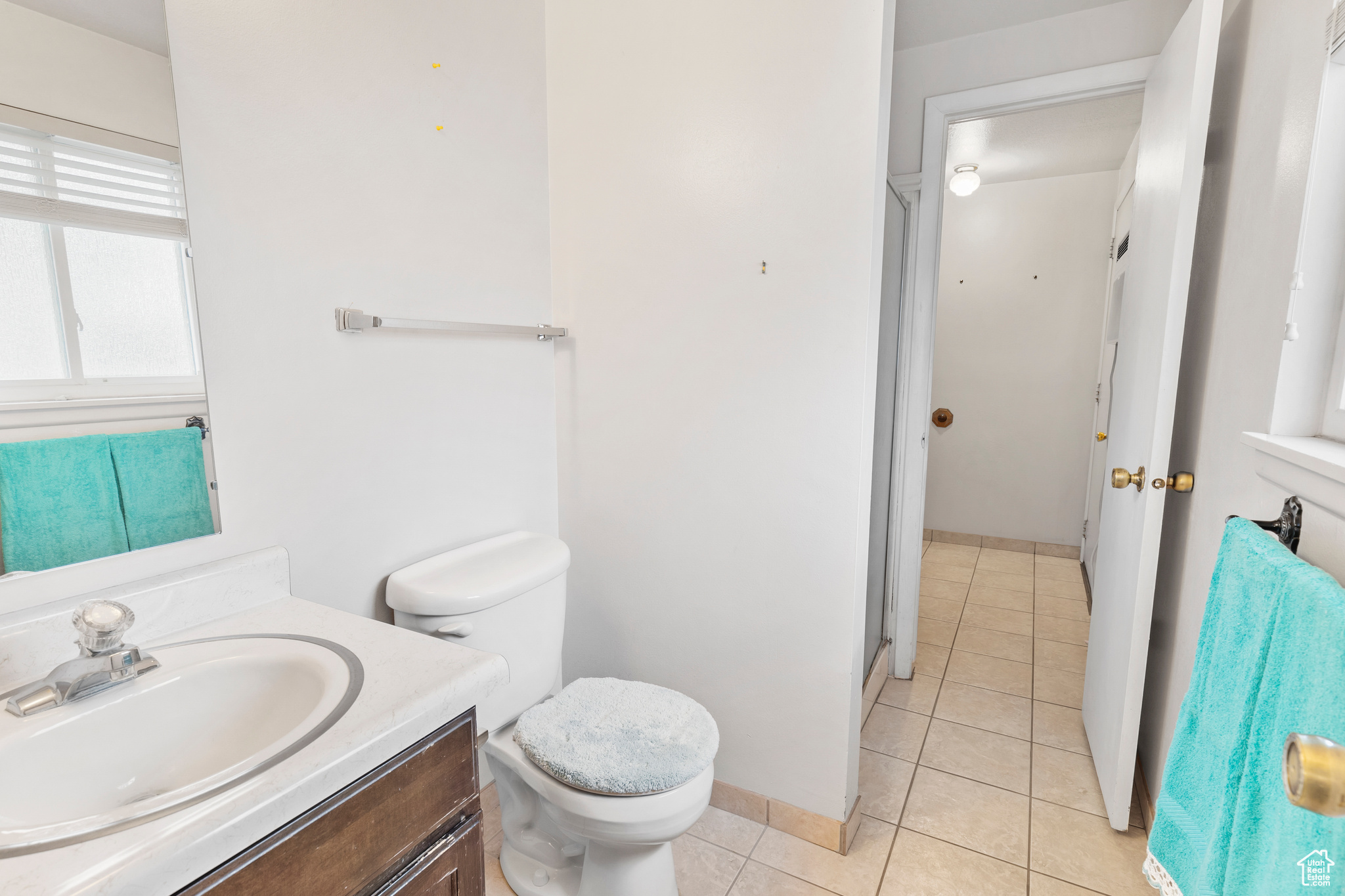 Bathroom with tile flooring, vanity, and toilet