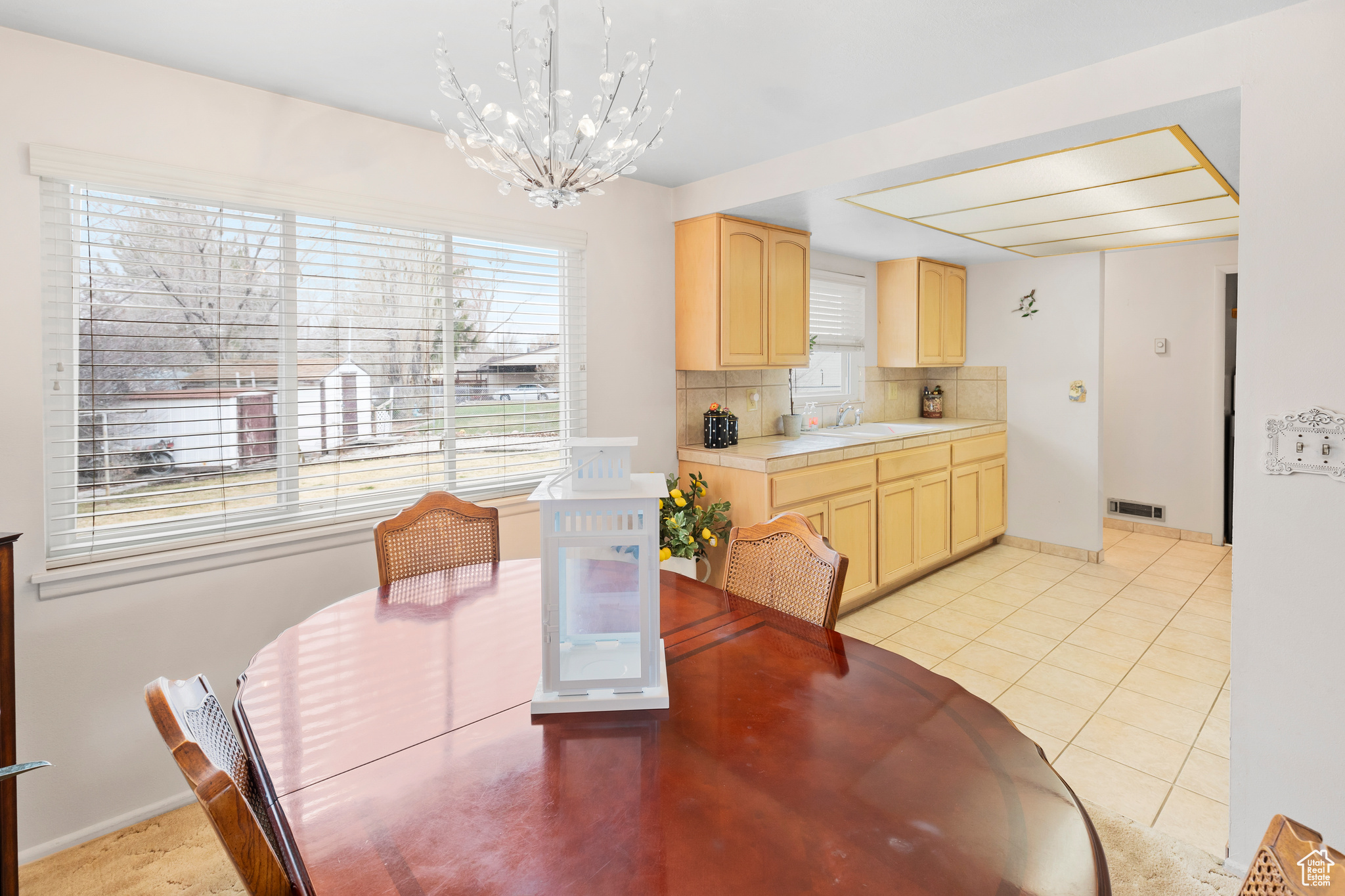 Tiled dining room featuring sink and an inviting chandelier