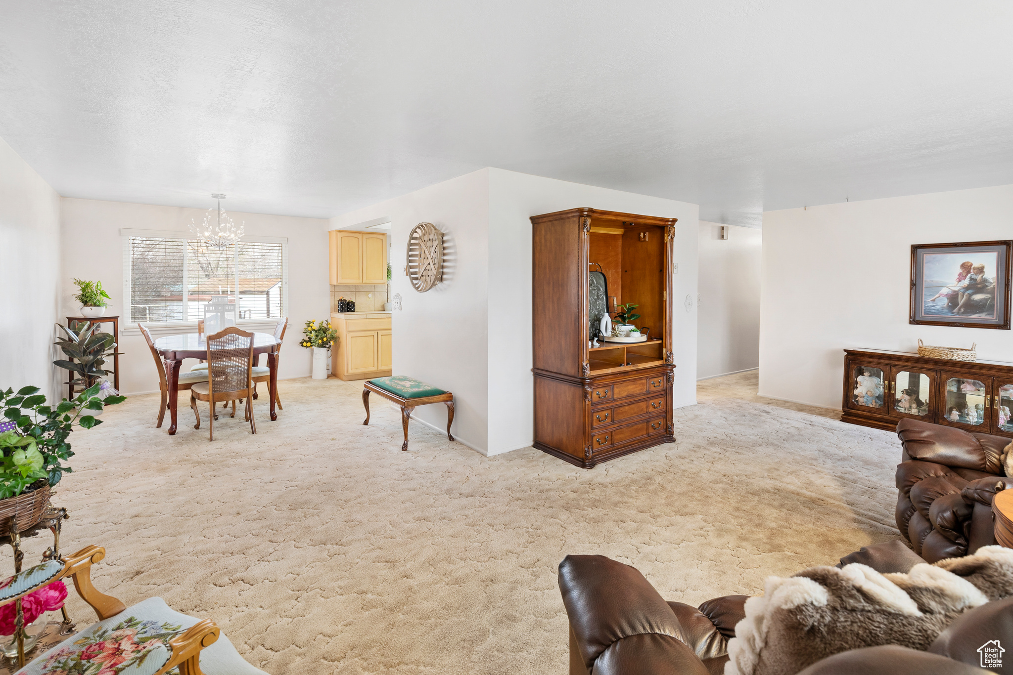 Carpeted living room with a notable chandelier