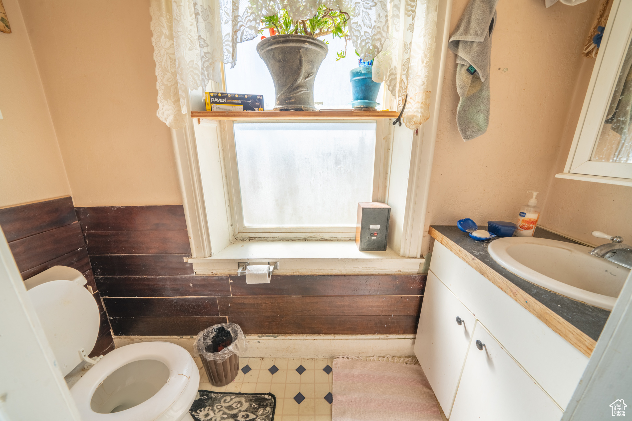 Half bathroom with vanity, toilet, tile flooring, and a healthy amount of sunlight