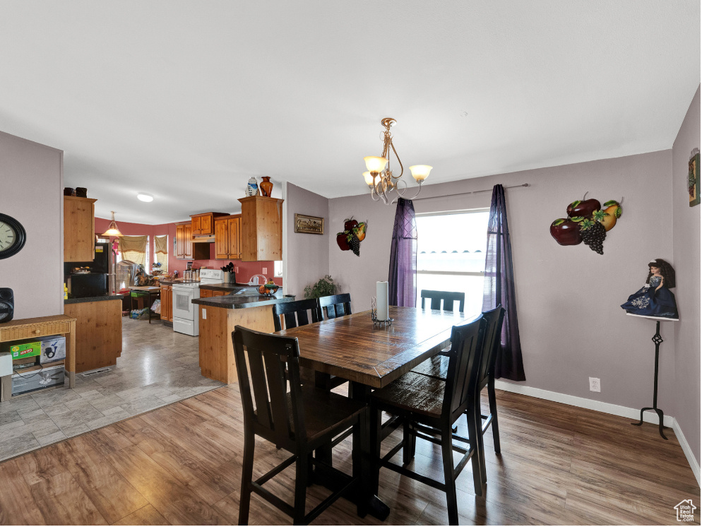 Dining room with light wood-type flooring, sink, and a notable chandelier