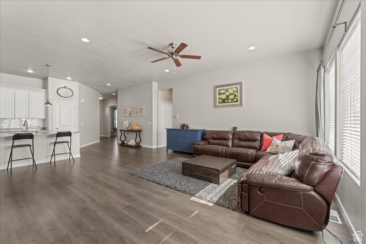 Living room featuring ceiling fan, dark hardwood / wood-style flooring, and sink