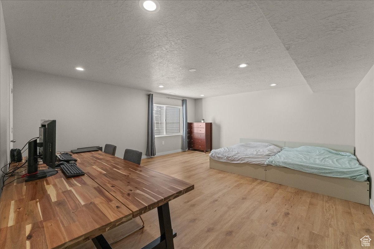 Bedroom featuring light wood-type flooring and a textured ceiling