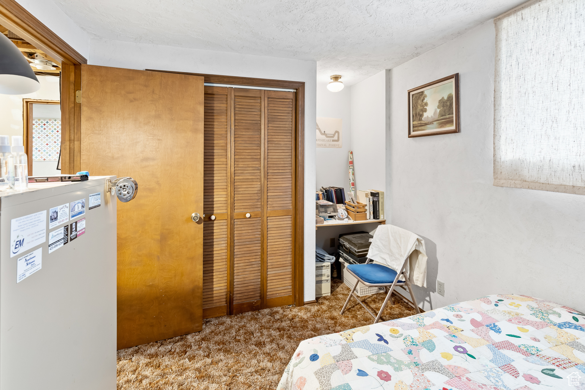 Carpeted bedroom with a closet and a textured ceiling