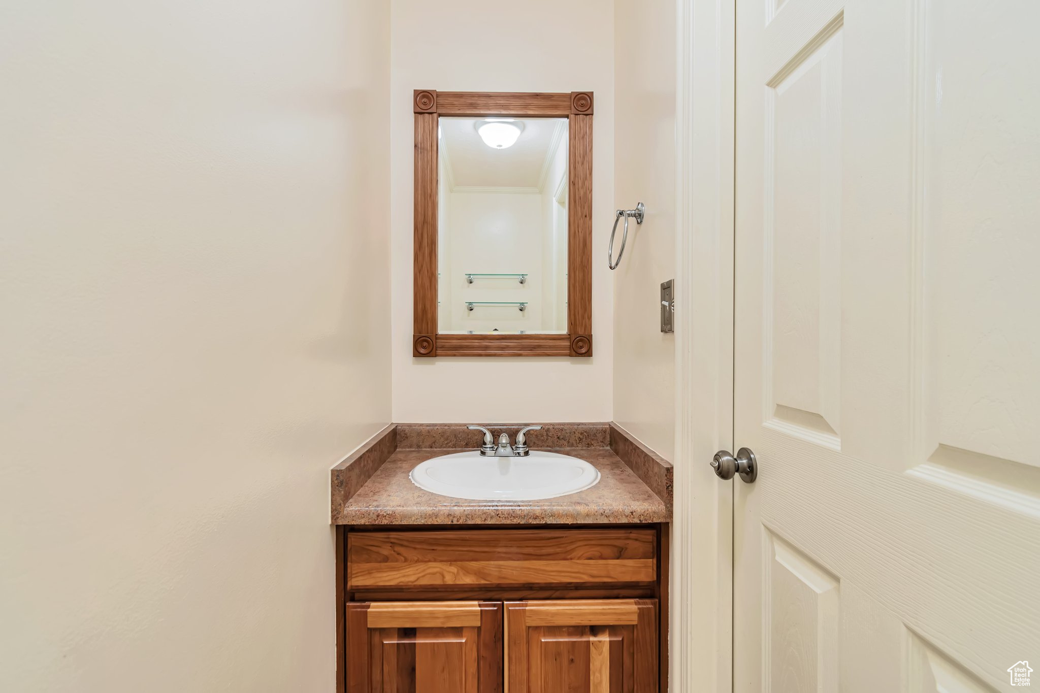 half Bathroom featuring wood mirror and vanity.