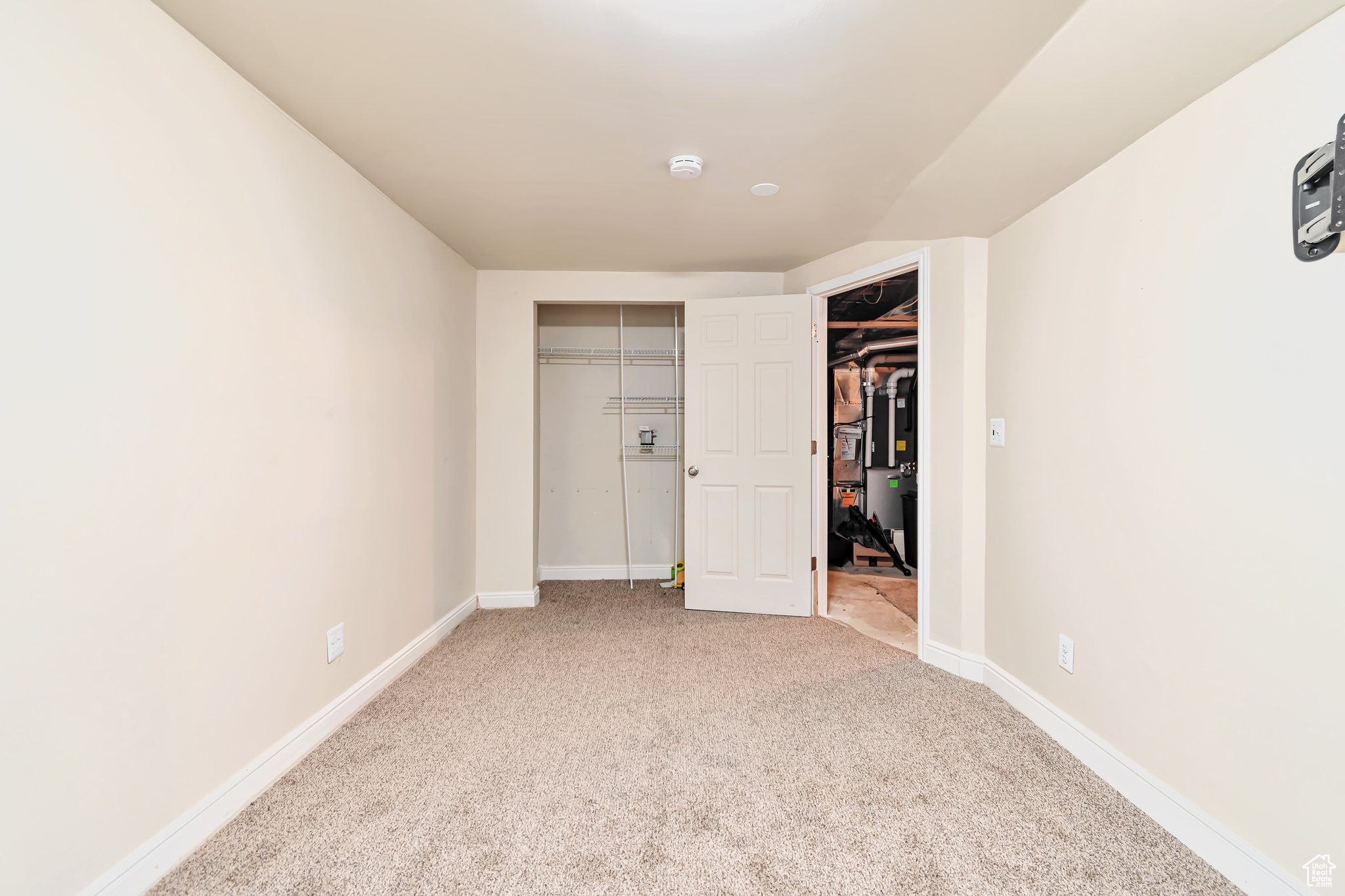 carpeted bedroom with a closet with shelving.
