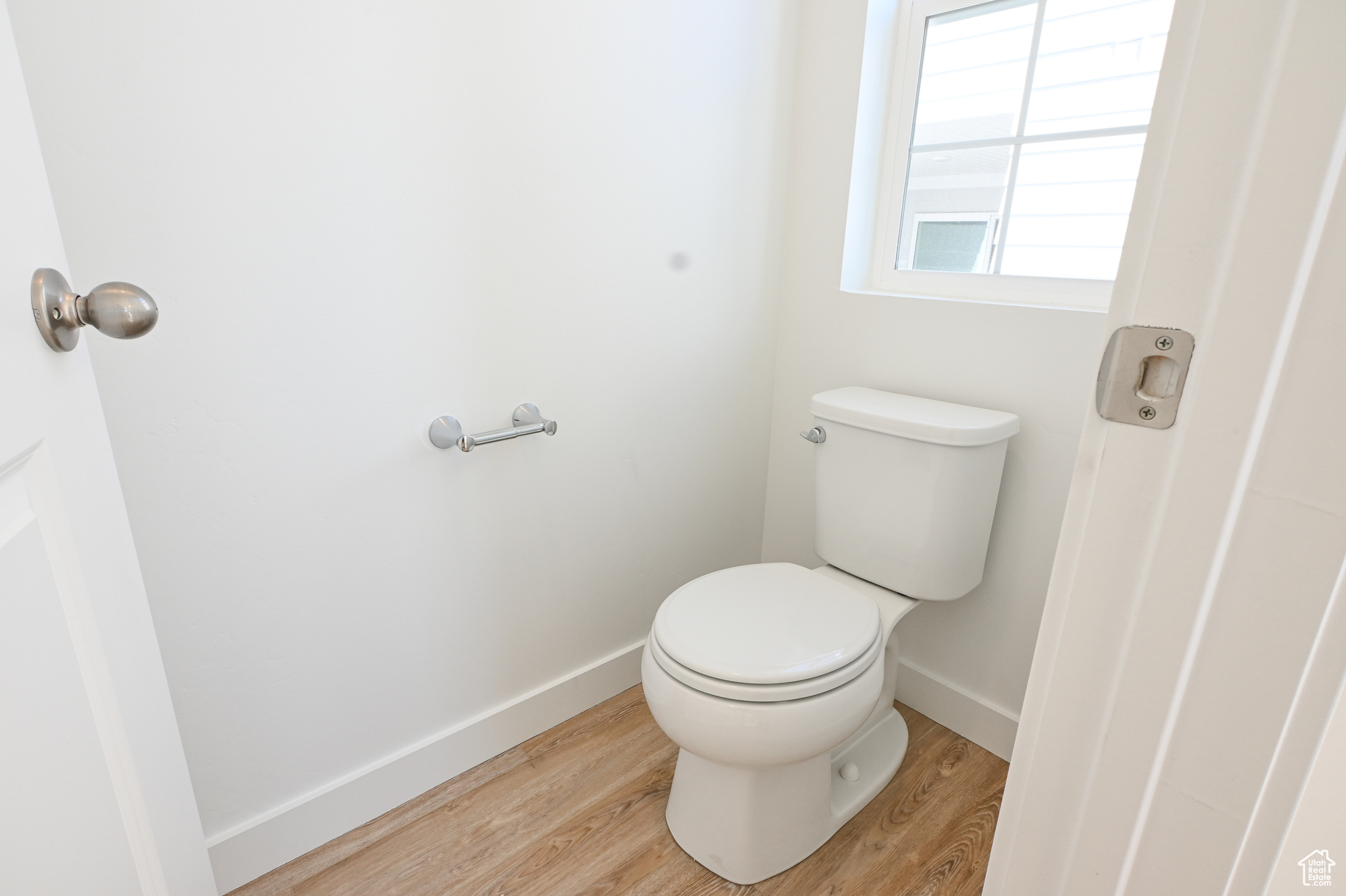 Bathroom with toilet and hardwood / wood-style flooring