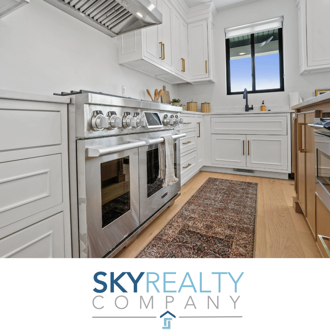 Kitchen featuring double oven range, white cabinets, custom exhaust hood, and light hardwood / wood-style flooring