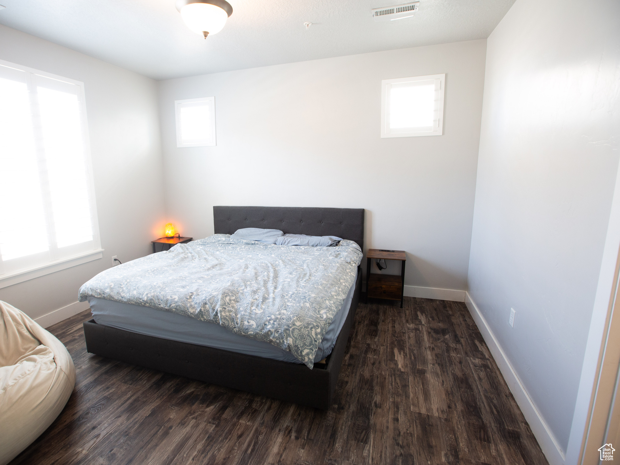 Bedroom with dark hardwood / wood-style flooring