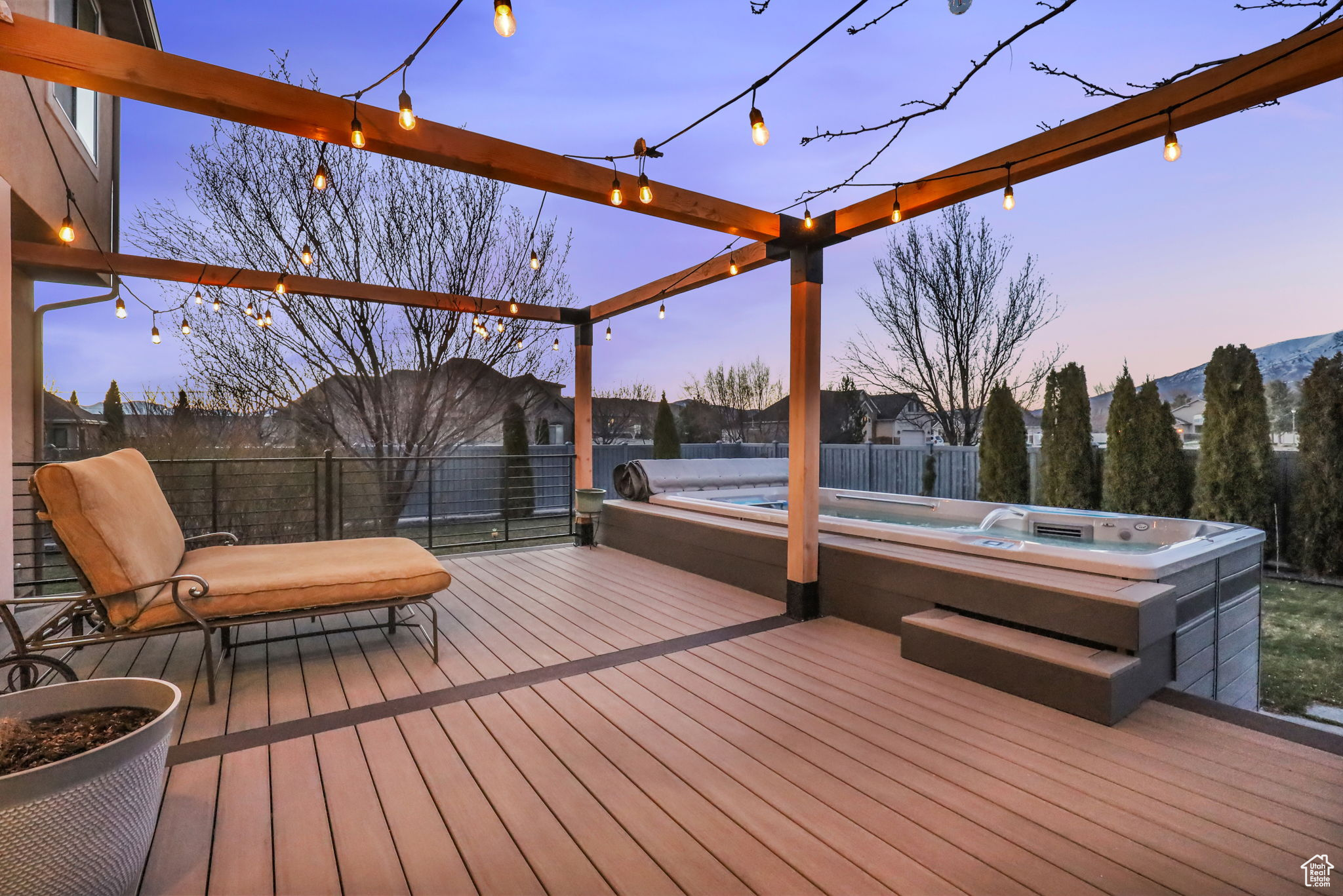 Deck at dusk featuring a hot tub