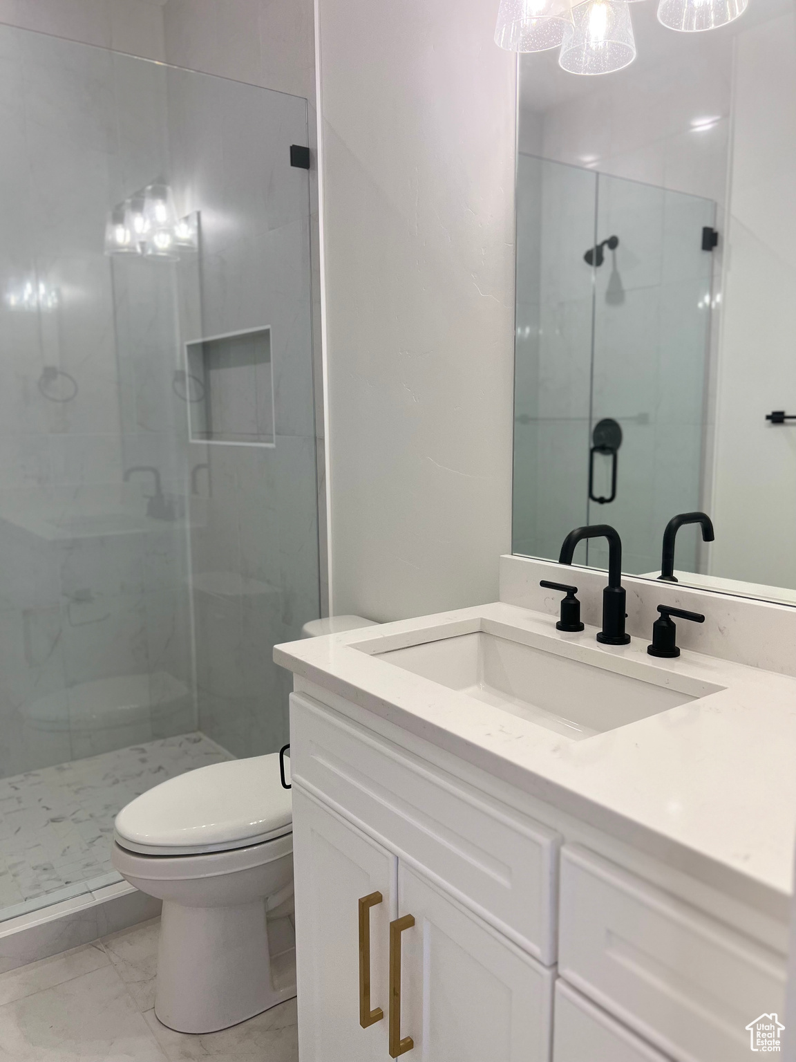 Bathroom with a shower with door, tile flooring, oversized vanity, and toilet