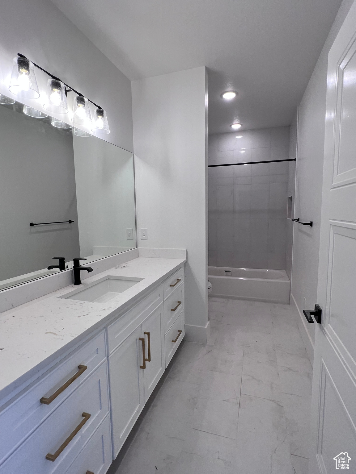 Full bathroom with toilet, tile flooring, tiled shower / bath combo, and vanity