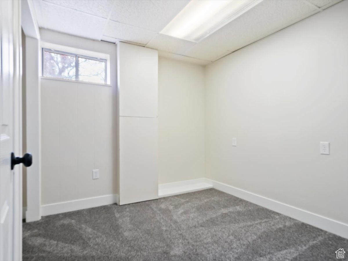 Carpeted empty room featuring a paneled ceiling