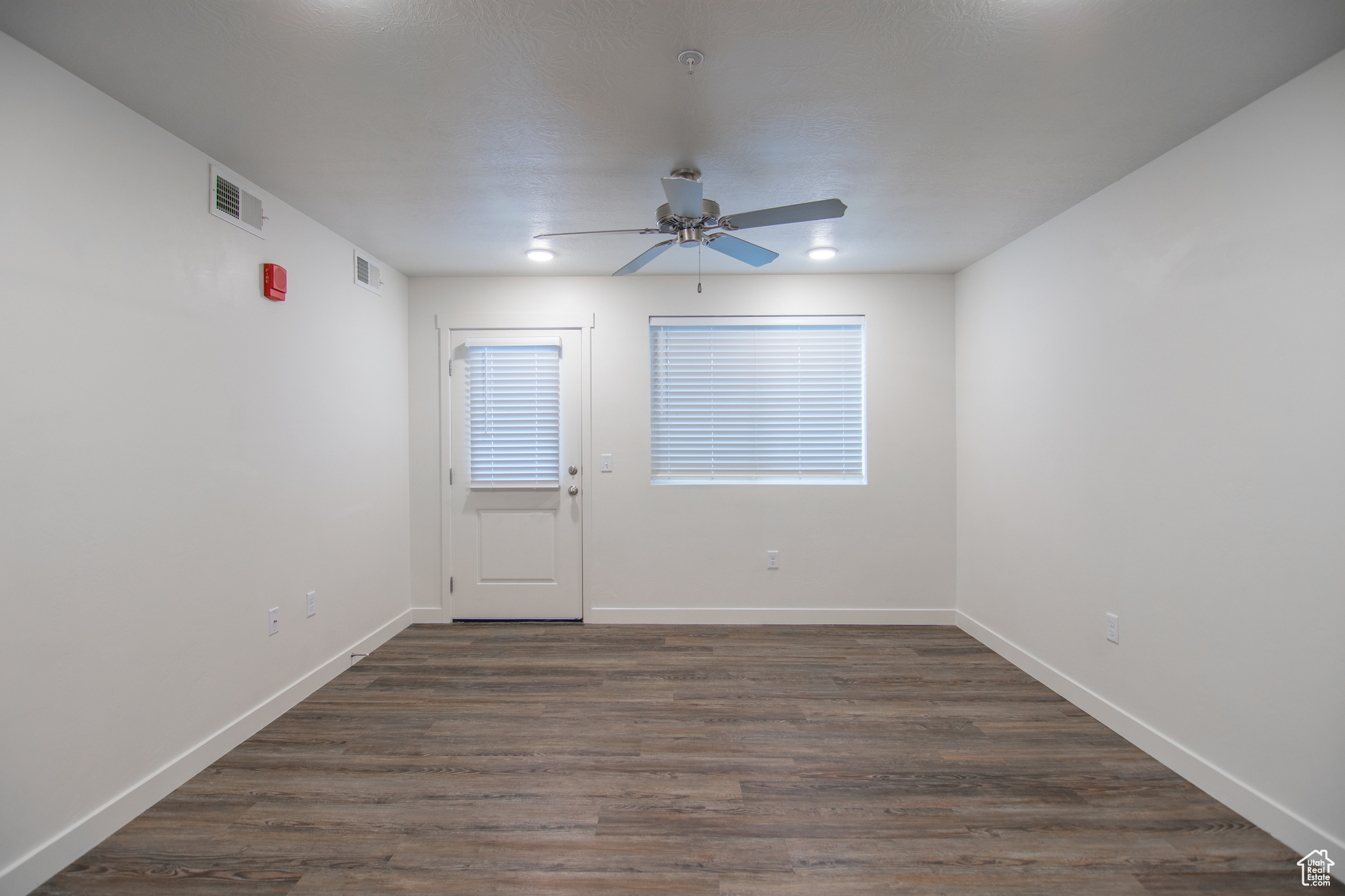 Family room with ceiling fan and dark hardwood / wood-style floors