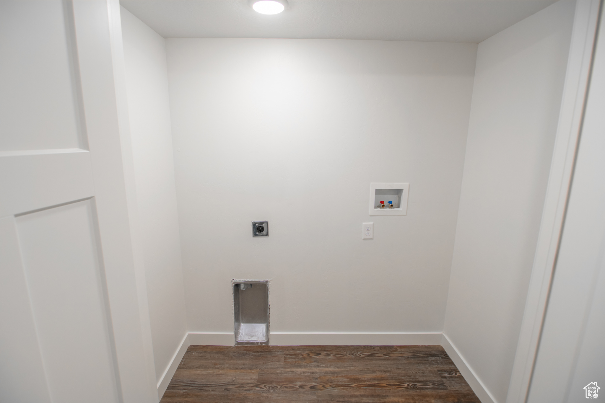 Washroom with washer hookup, electric dryer hookup, and dark hardwood / wood-style flooring