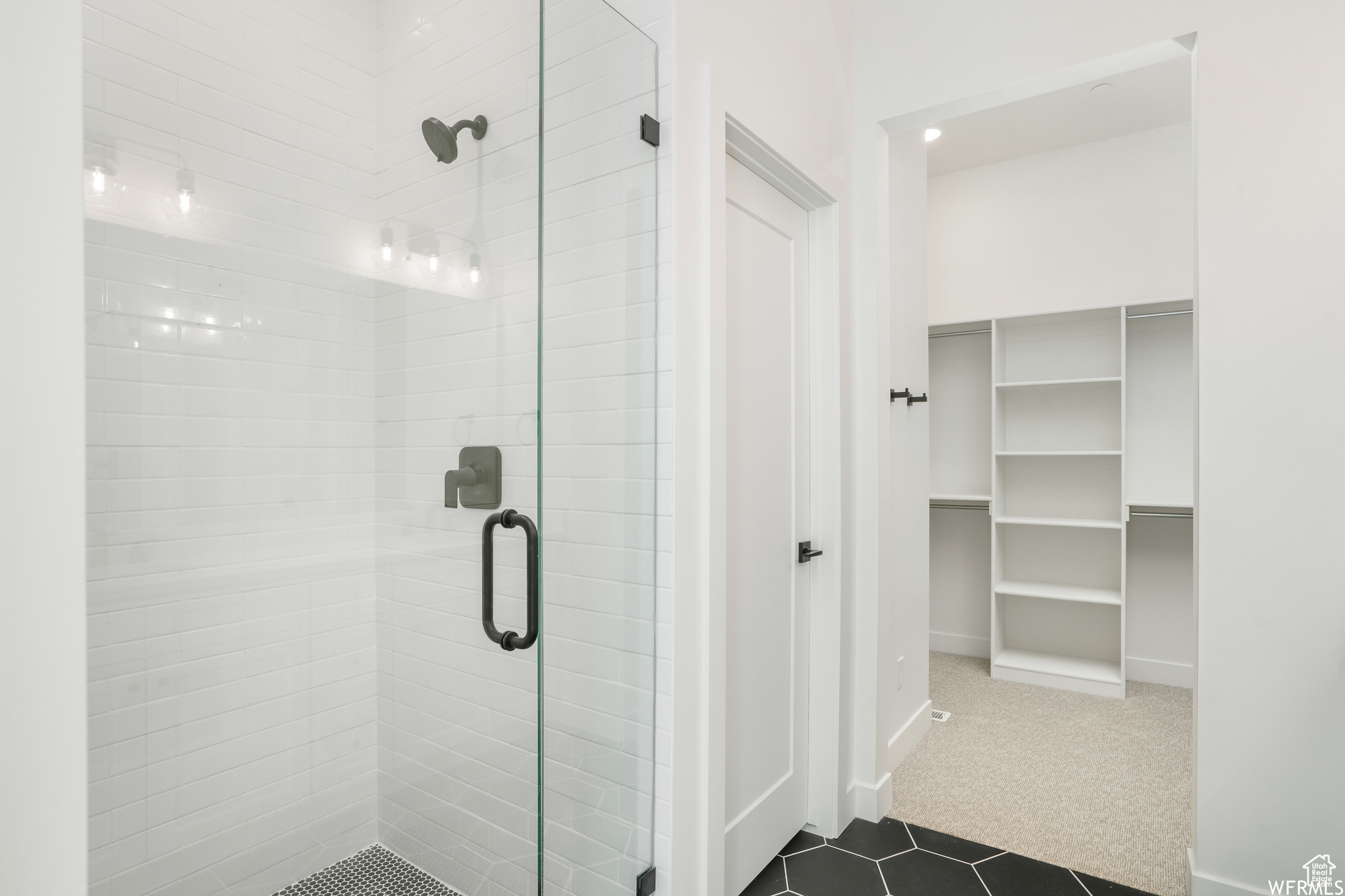 Bathroom featuring a shower with shower door and tile flooring