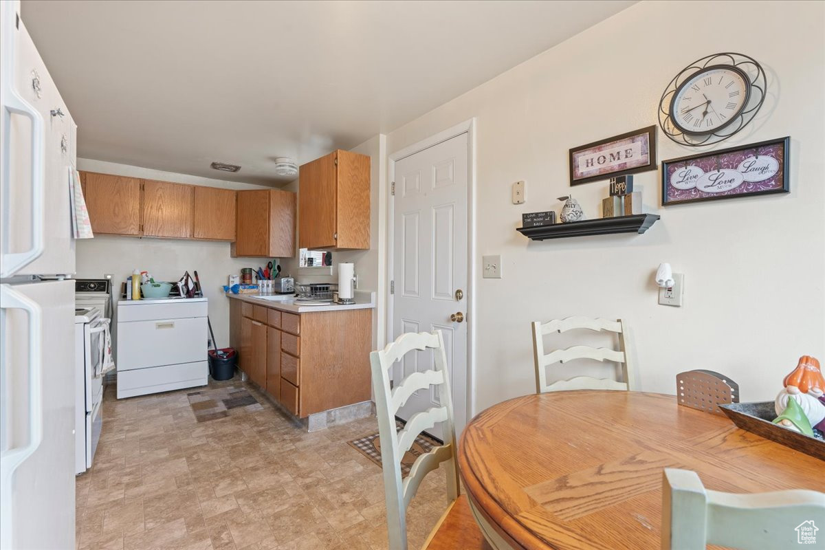 Kitchen featuring white appliances, washer / clothes dryer, and light tile flooring