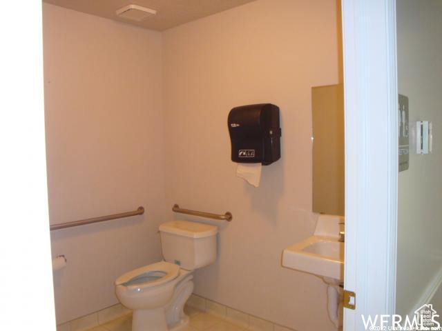 Bathroom featuring sink, tile floors, and toilet