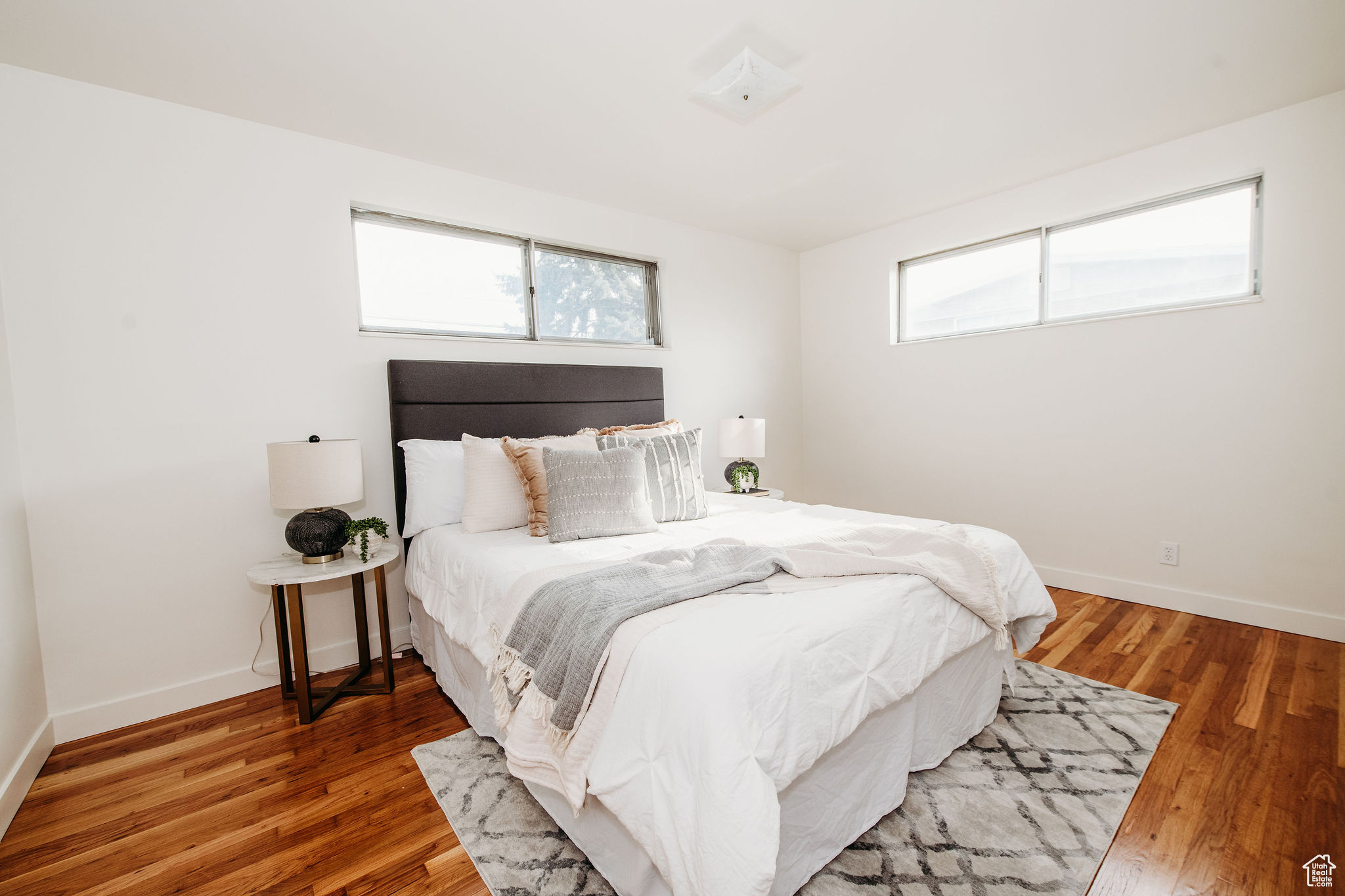 Bedroom with multiple windows and hardwood / wood-style flooring