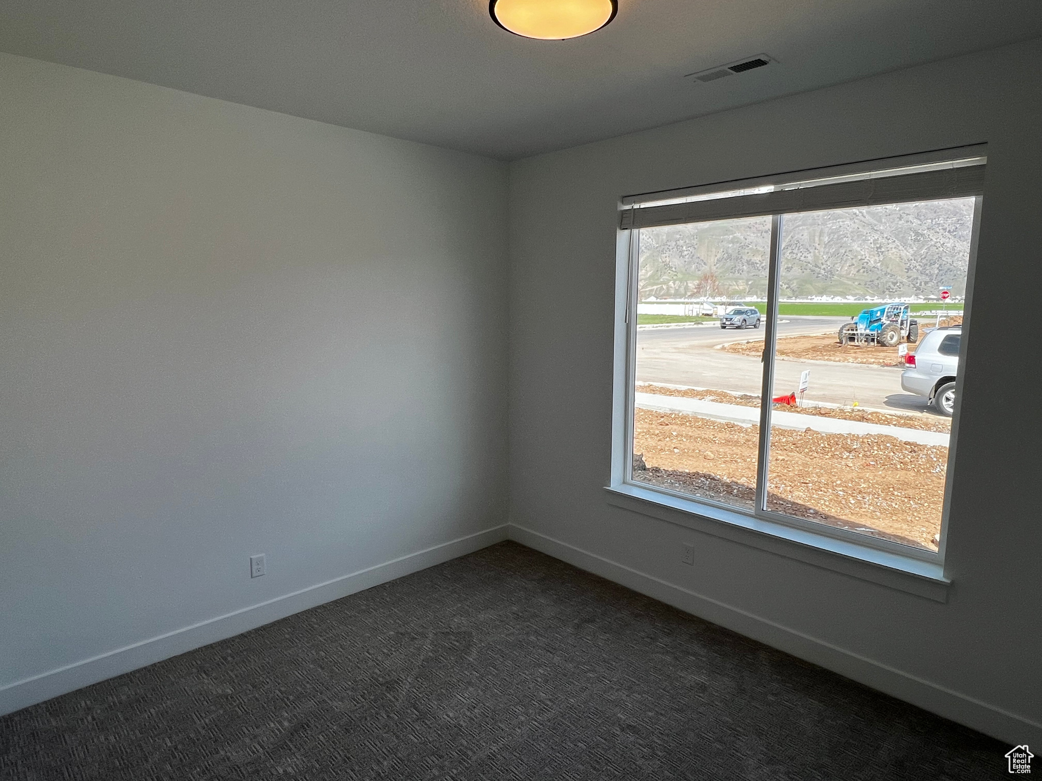 Empty room featuring dark carpet