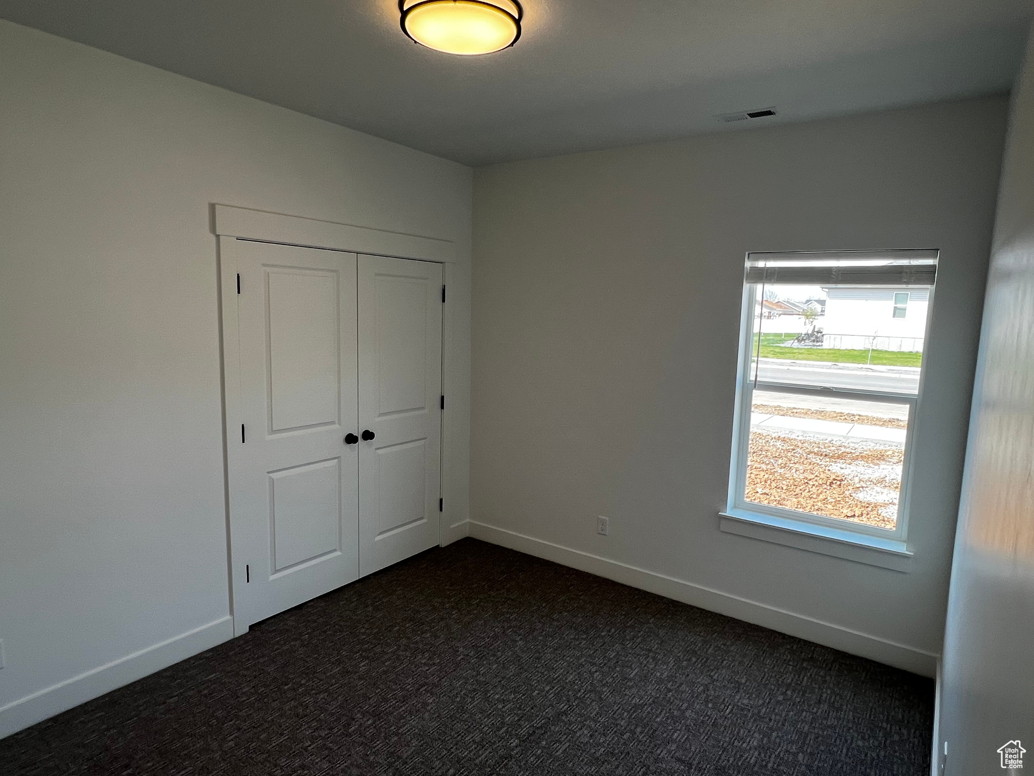 Unfurnished bedroom with a closet and dark colored carpet