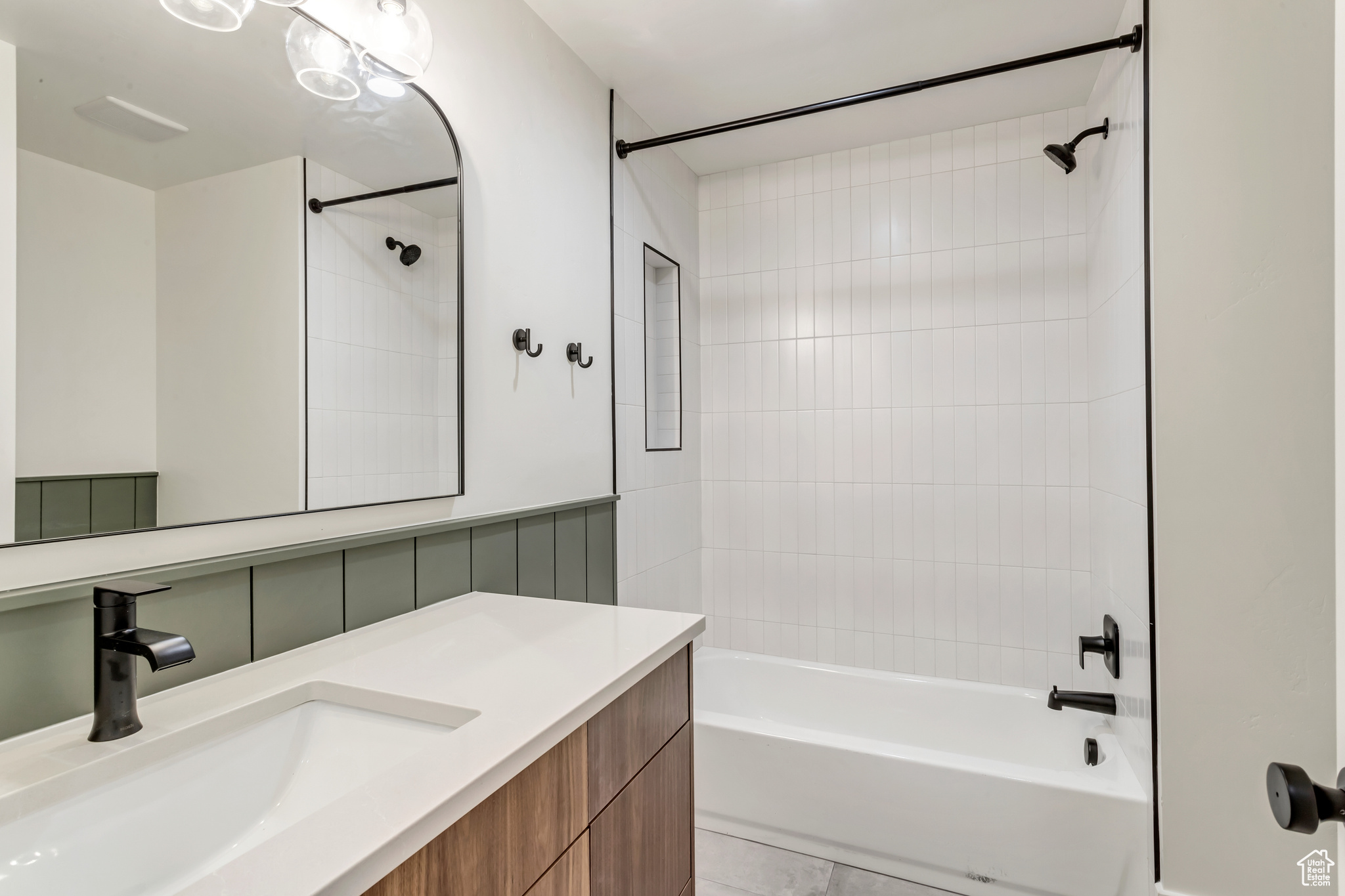 Bathroom featuring tiled shower / bath, tile floors, and vanity