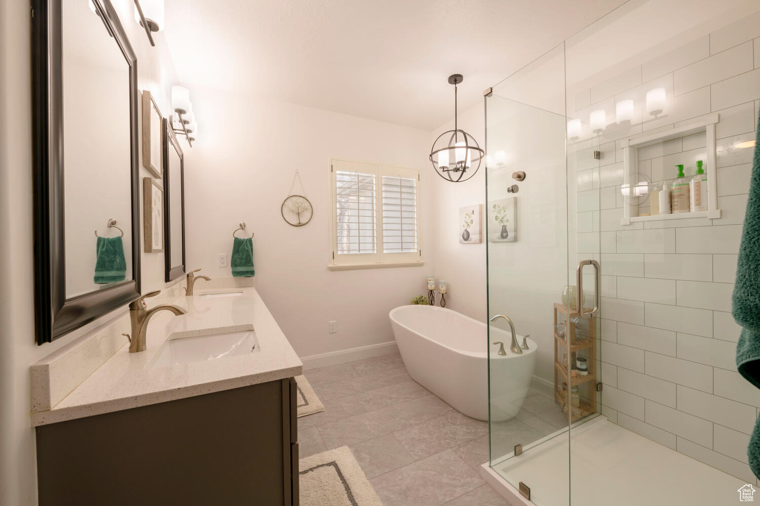 Bathroom with a notable chandelier, plus walk in shower, dual vanity, and tile flooring