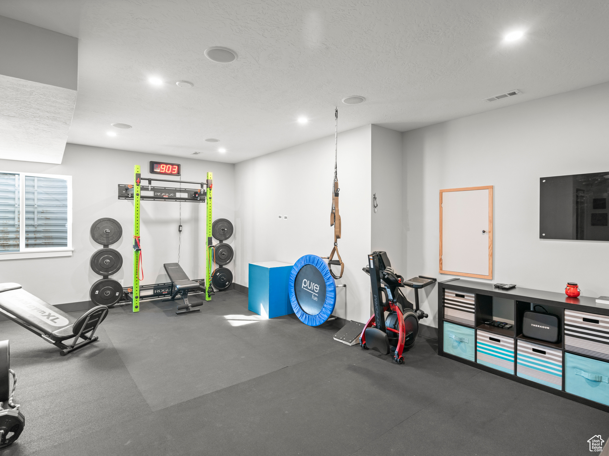 Exercise room with concrete flooring and a textured ceiling