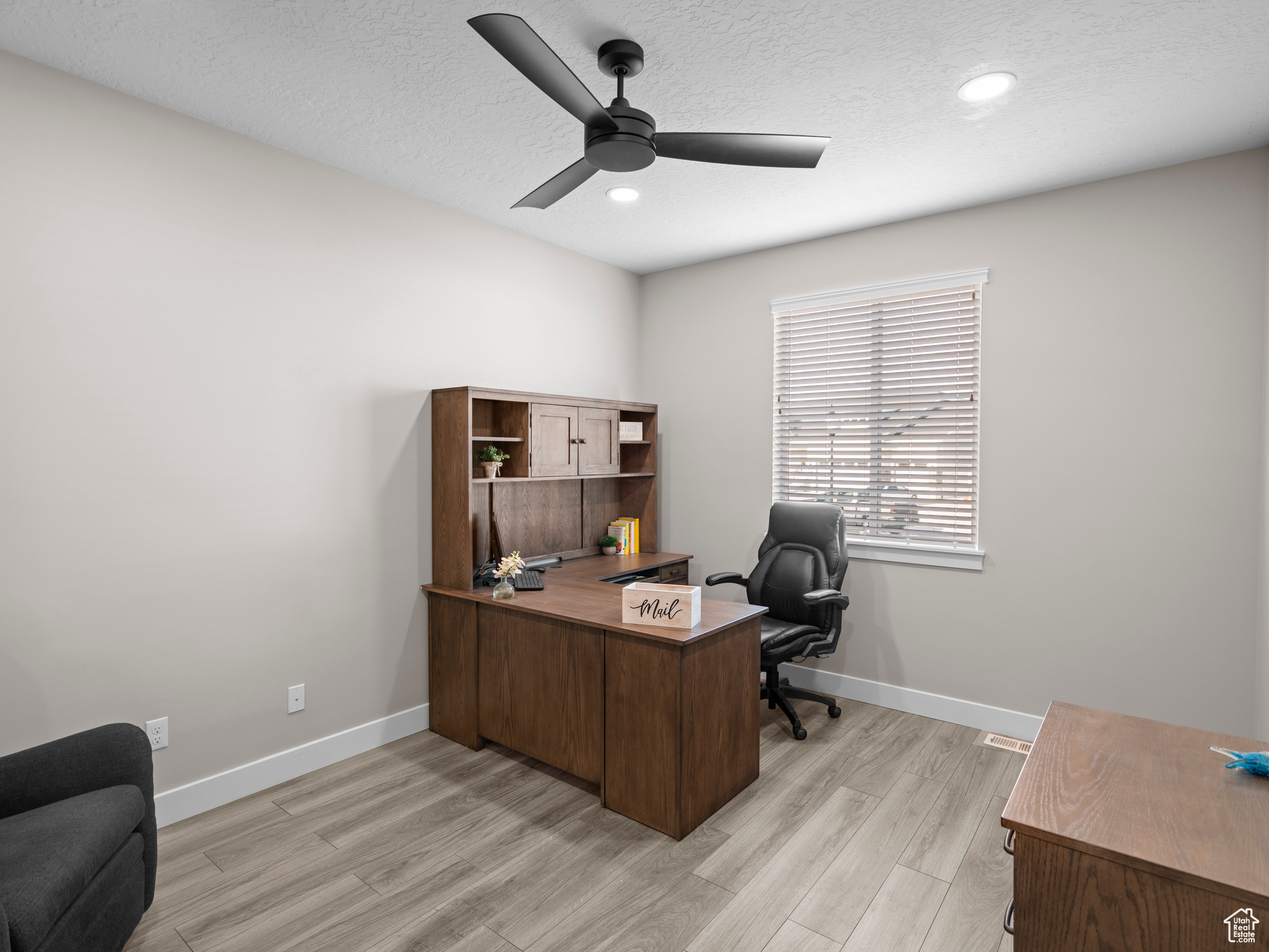 Office featuring a textured ceiling, light hardwood / wood-style floors, and ceiling fan