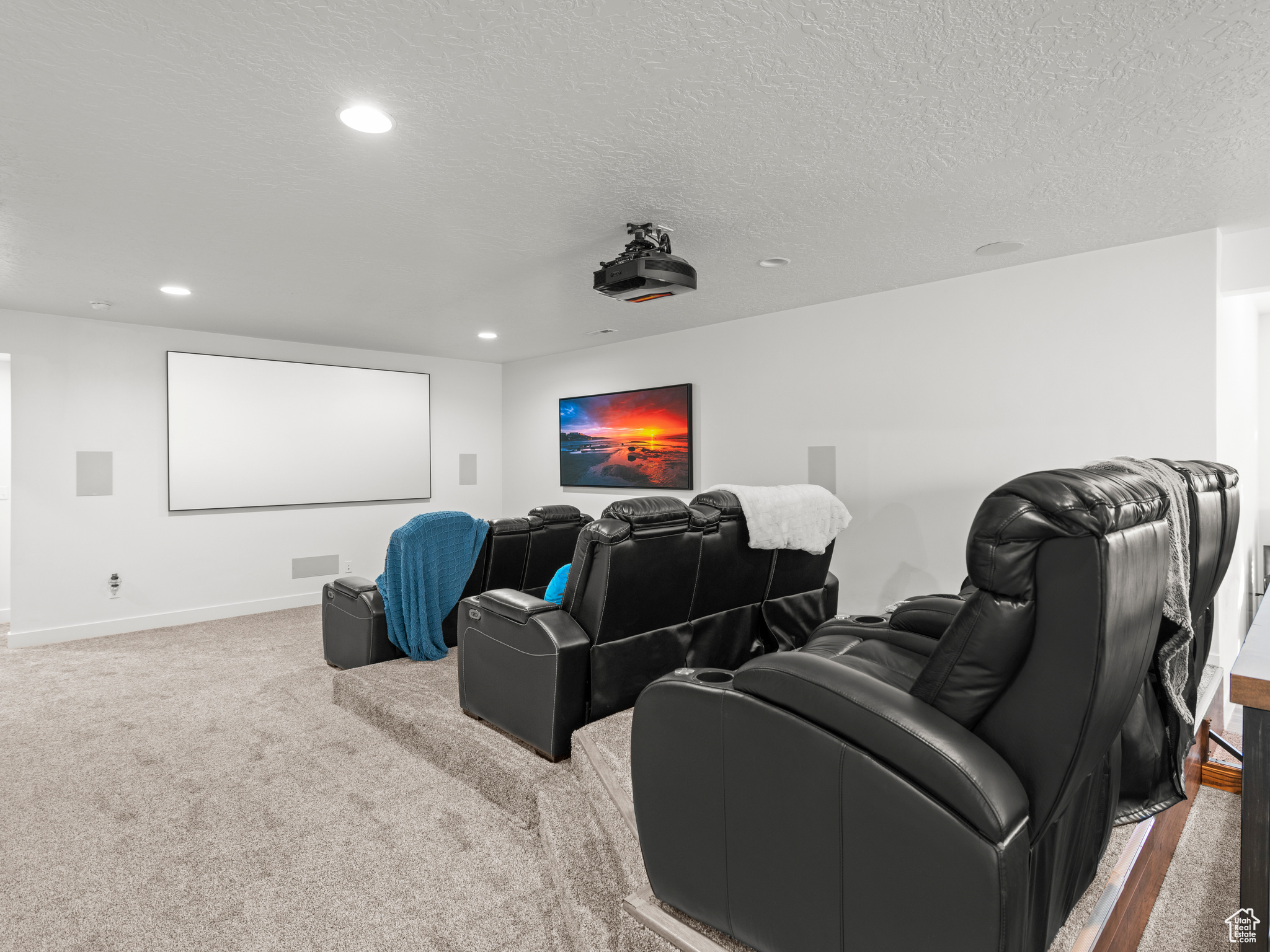 Home theater room featuring carpet floors and a textured ceiling