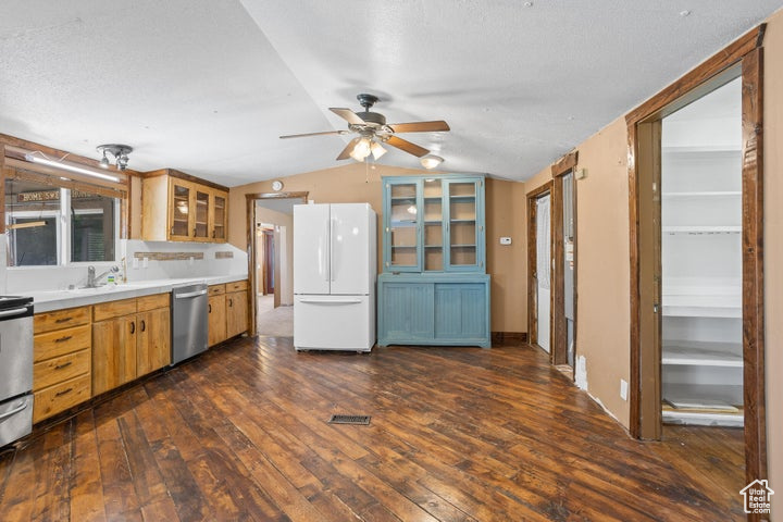 Kitchen featuring ceiling fan, dark hardwood / wood-style floors, white refrigerator, and stainless steel dishwasher