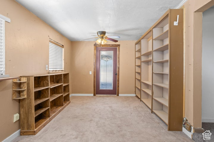 Interior space featuring light carpet and ceiling fan