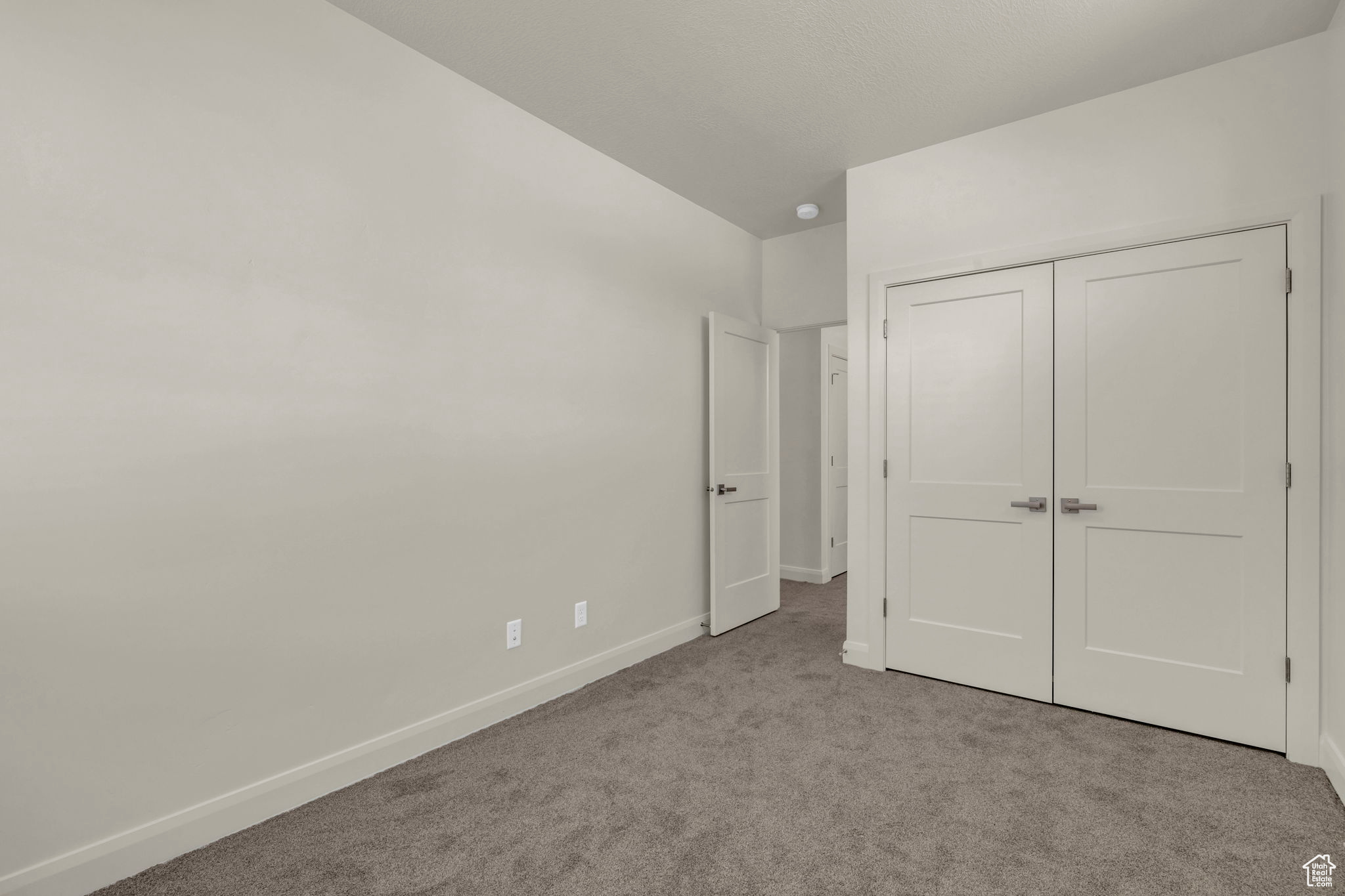 Unfurnished bedroom with a closet and light colored carpet