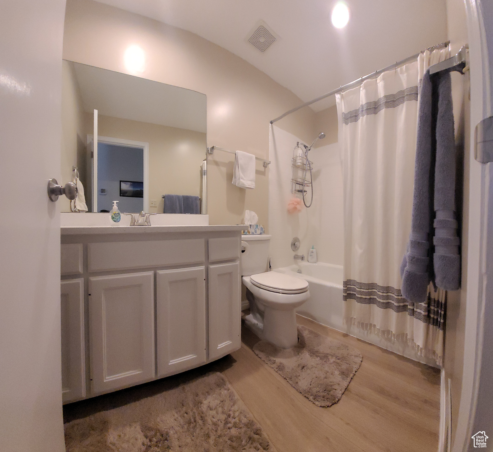 2nd bathroom in Hallway upstairs, with vanity, shower / bath combination with curtain, wood-type flooring, and toilet