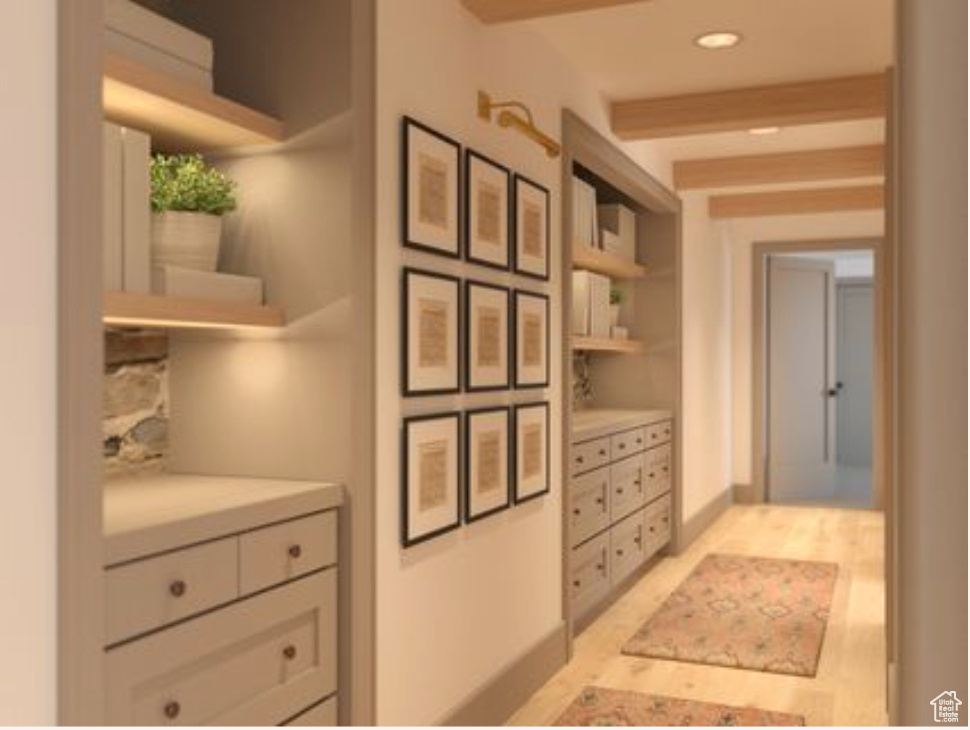 Interior space with white cabinets, light tile flooring, and beamed ceiling