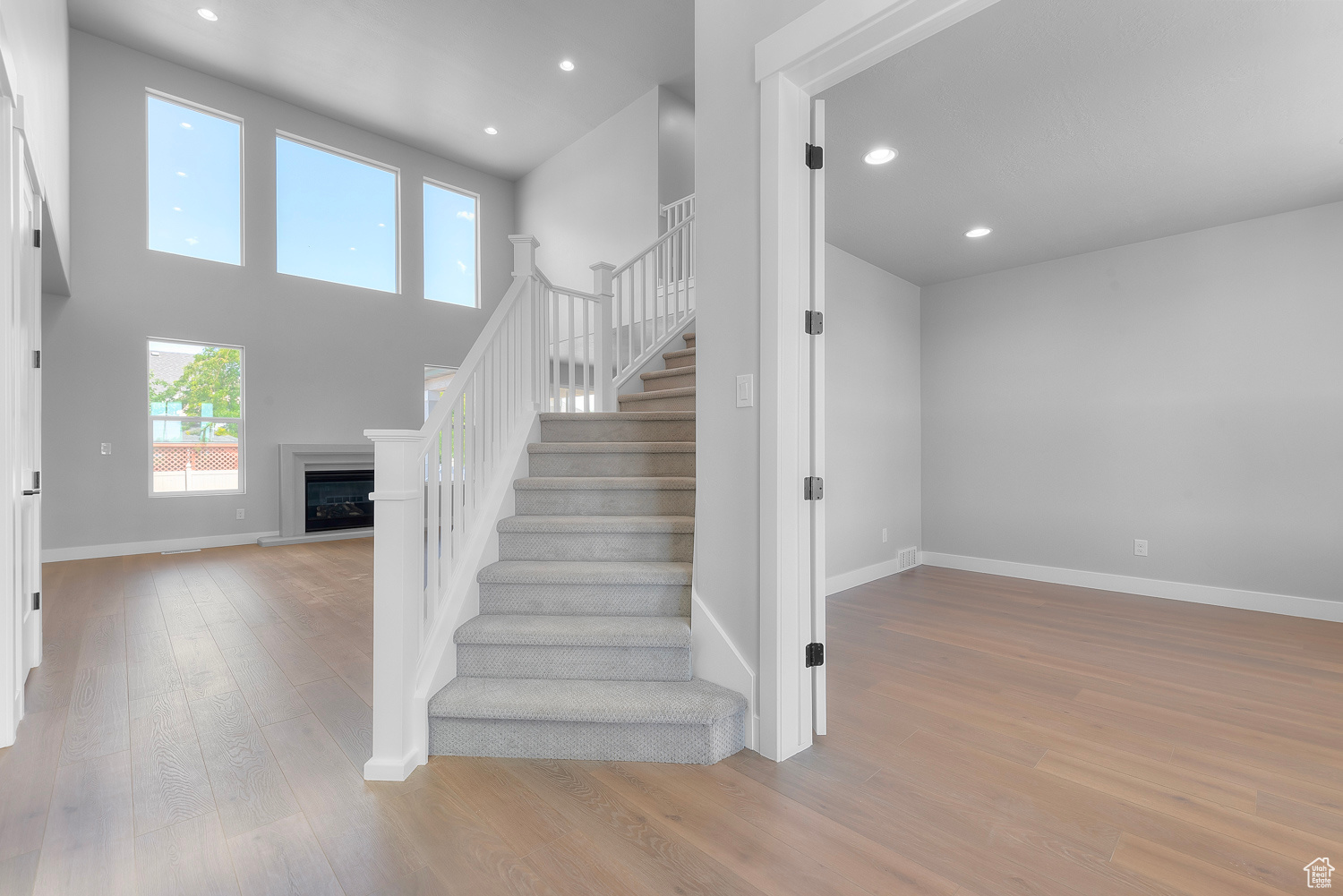 Staircase featuring a towering ceiling and hardwood / wood-style floors