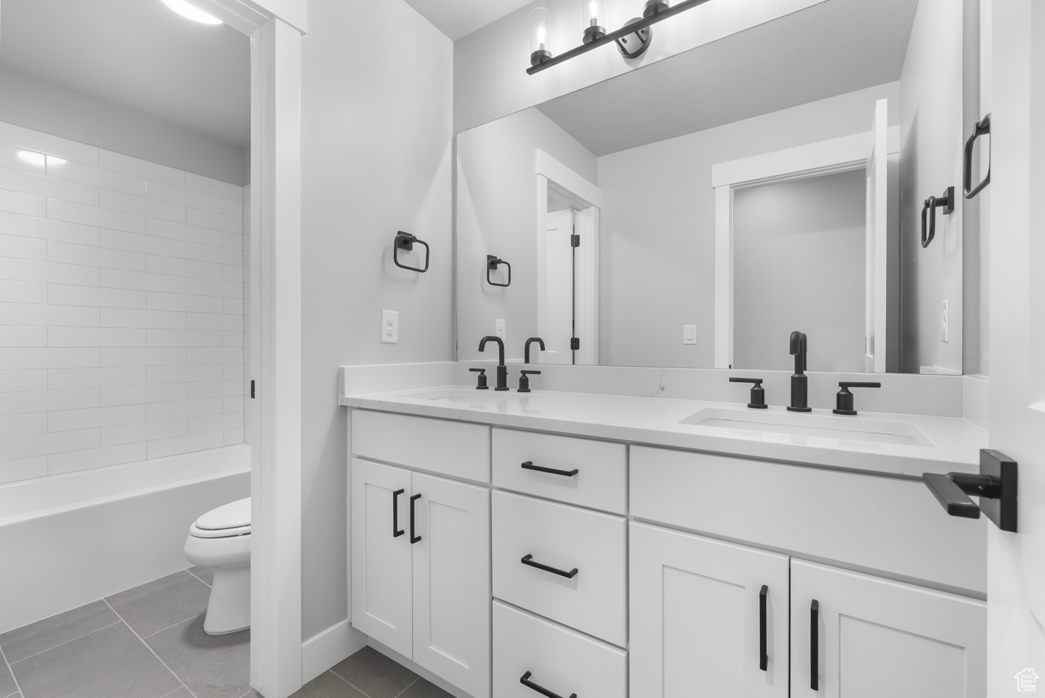 Full bathroom with tiled shower / bath, toilet, tile patterned flooring, and vanity