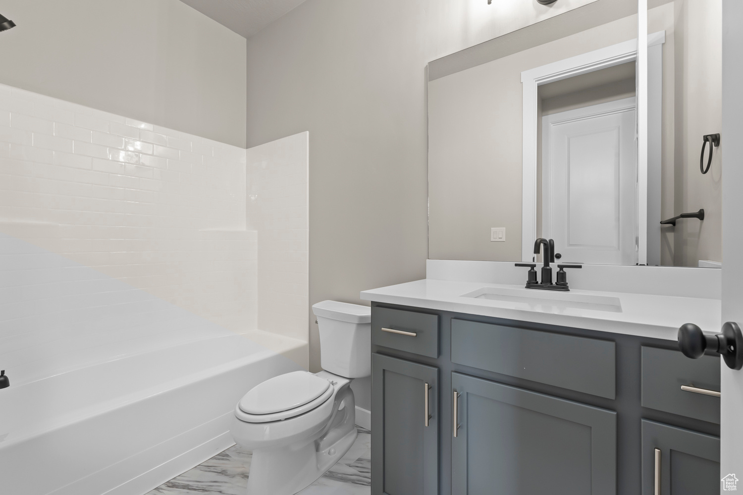 Full bathroom with tile patterned floors, toilet, vanity, and shower / tub combination