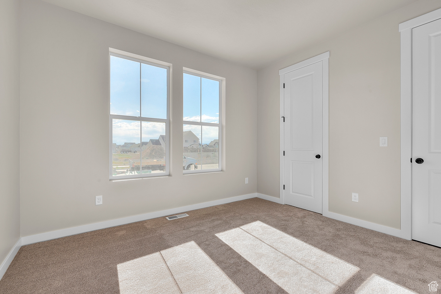 Spare room featuring plenty of natural light and carpet floors