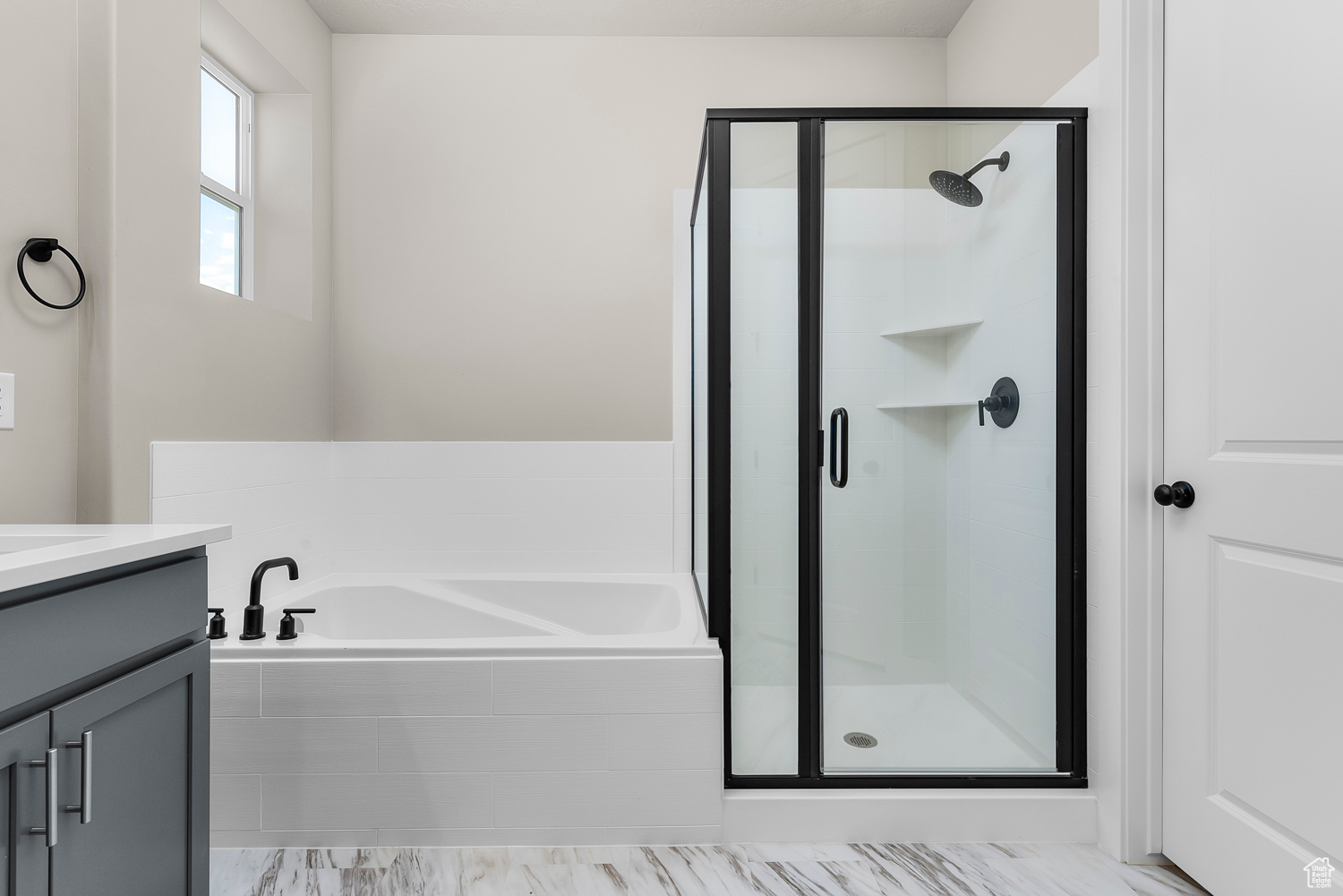 Bathroom featuring vanity, shower with separate bathtub, and tile patterned flooring