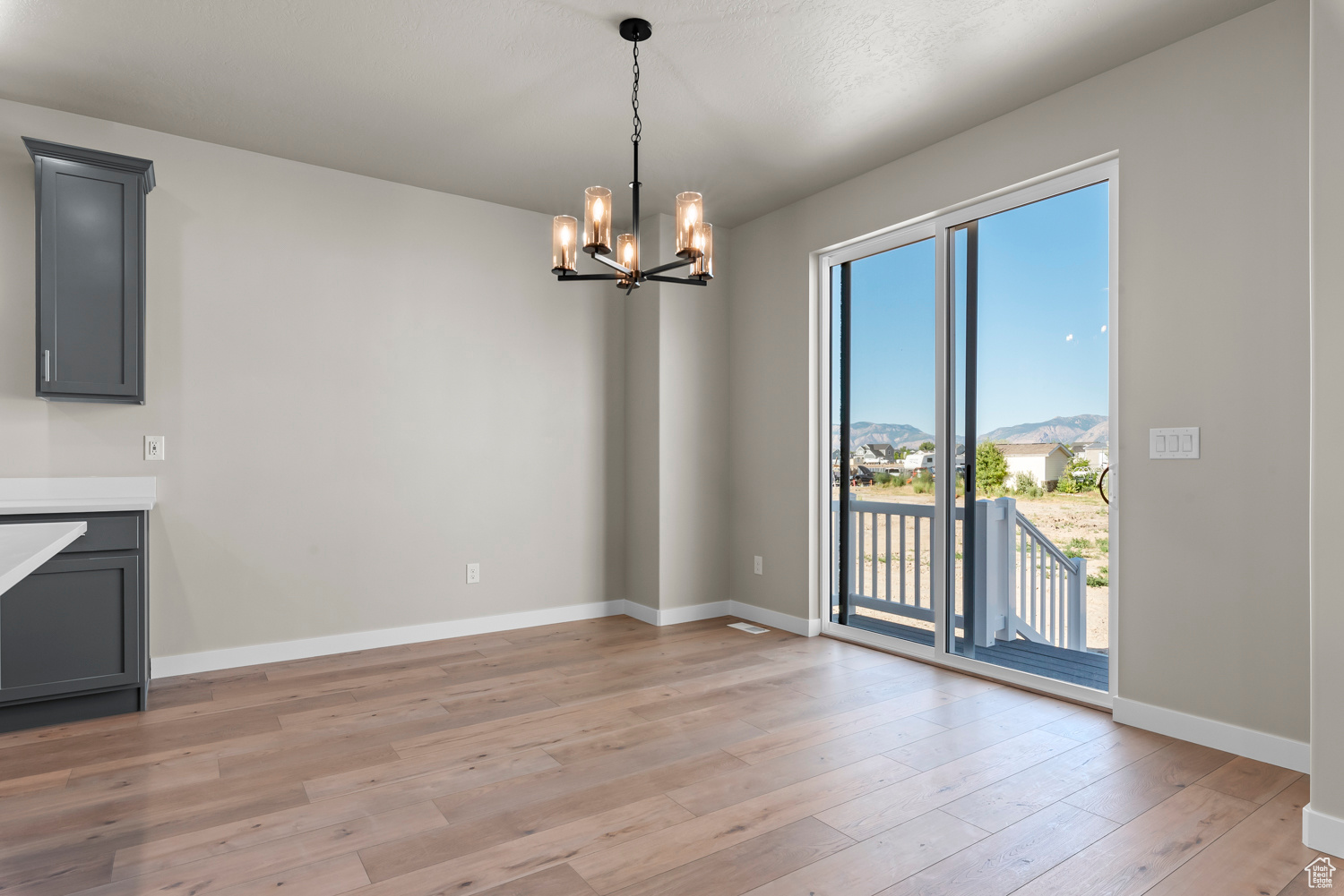 Unfurnished dining area featuring light hardwood / wood-style floors and an inviting chandelier