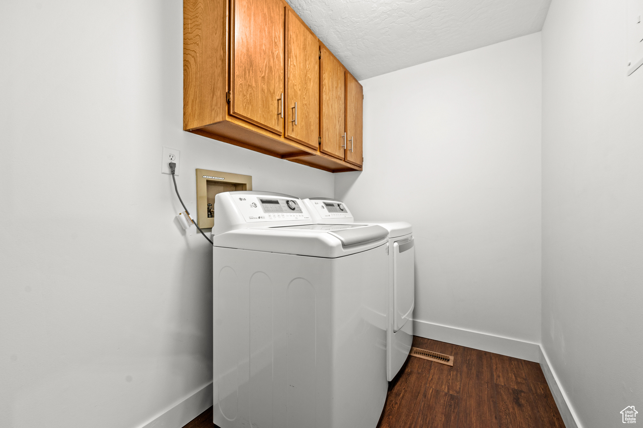 Laundry area with washer and dryer, washer hookup, dark wood-type flooring, and cabinets