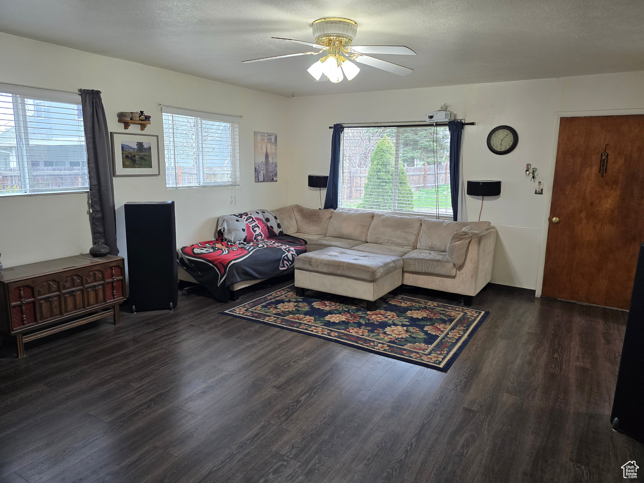 Living room featuring a wealth of natural light, ceiling fan, and dark hardwood / wood-style flooring