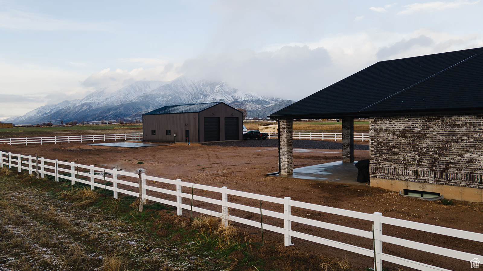 View of stable featuring a mountain view, a rural view, and an outdoor structure